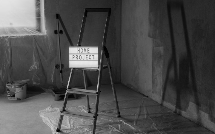 Black and white image of a step ladder with a 'home project' sign in a renovation setting. — Basics of Asbestos Insulation