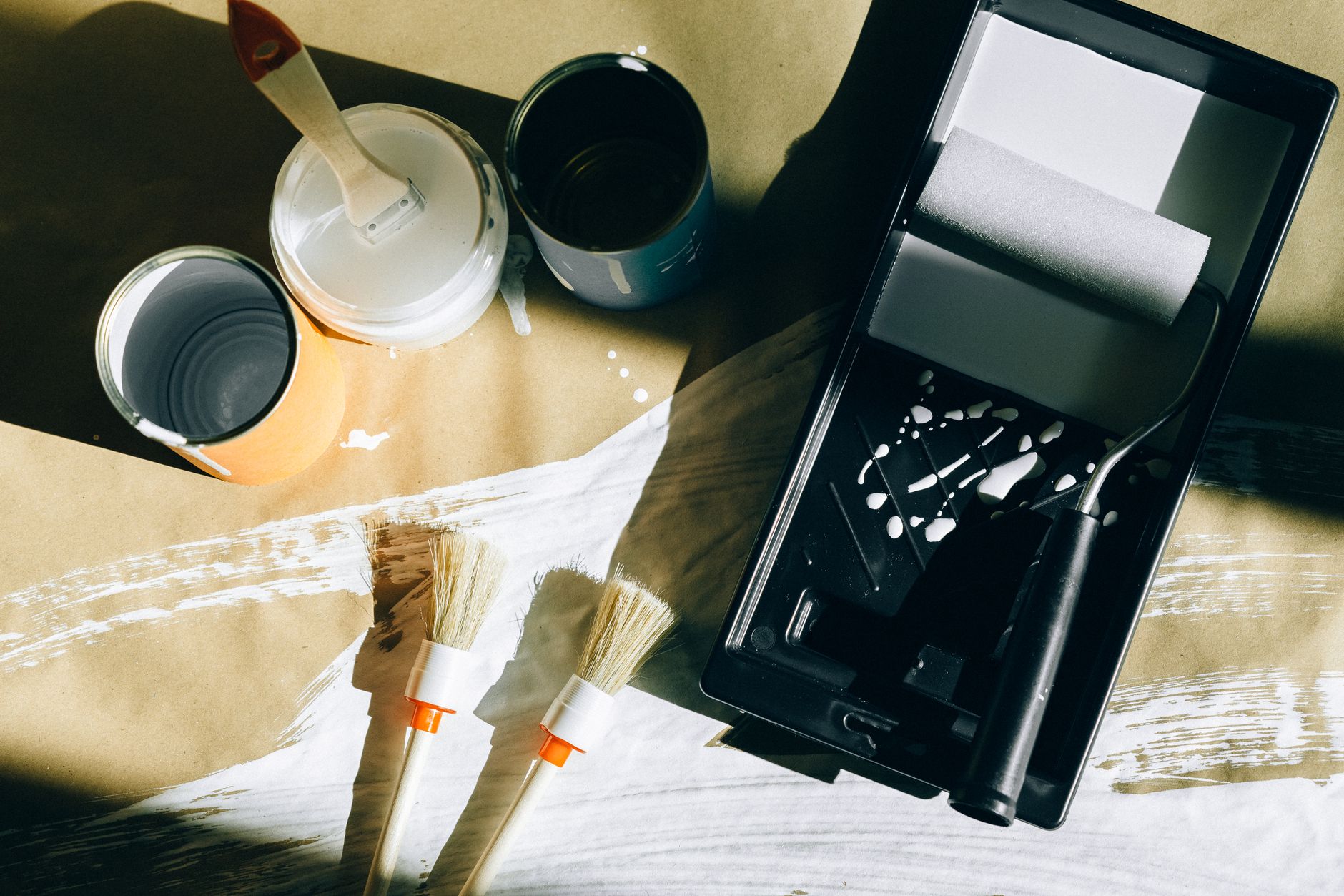 Top view of painting tools including brushes, rollers, and paint cans on paper. — Vavada promokoodi kasutamine ja eelised 202